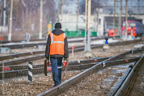 Railway worker walks on railway station territory.