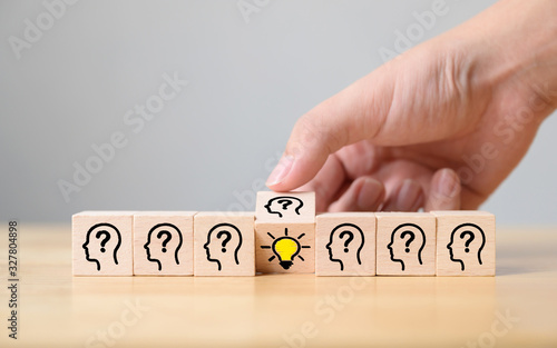 Concept creative idea and innovation. Hand flip over wooden cube block with head human symbol and light bulb icon
