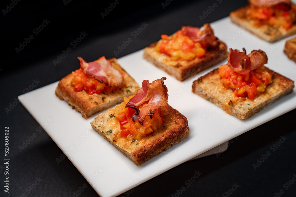 toast with vegetables and bacon, black background. toast with vegetables and bacon, black background.