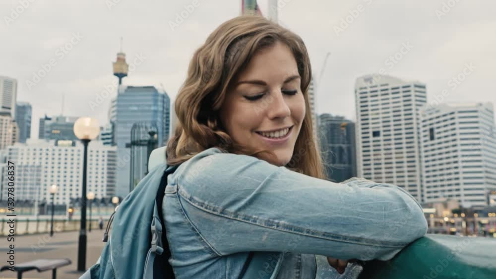 Alluring brunette smiles at the camera with the Sydney Tower and city skyline in the background Alluring brunette smiles at the camera with the Sydney Tower and city skyline in the background