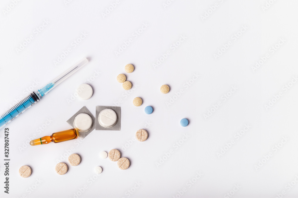 Medicaments on a white background. Syringe, pills, injection and other drugs to cure people and support health. Medicines and tablets against diseases and viruses.