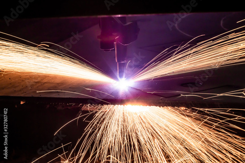 Plasma cutting of metal with a cnc. Plasma cutting machine cutting steel sheet. Laser cutter in production. Industrial metal cutting by plasma laser. Sparks fly from laser