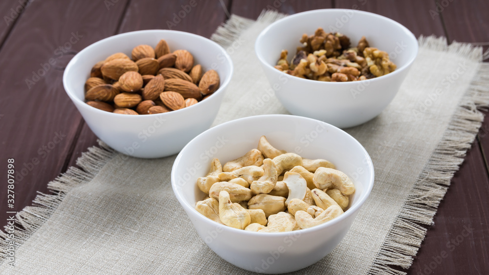 diet food concept, almonds, walnuts and cashew nuts on a wooden table diet food concept, almonds, walnuts and cashew nuts on a wooden table