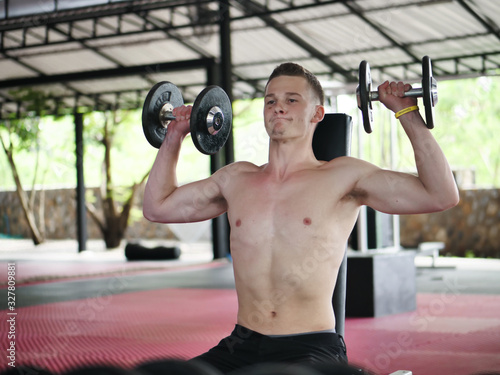 Handsome man doing the exercise with dumbbells, lifestyle concept.
