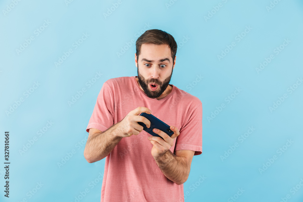 Nervous man isolated play games by mobile phone. Nervous man isolated play games by mobile phone.