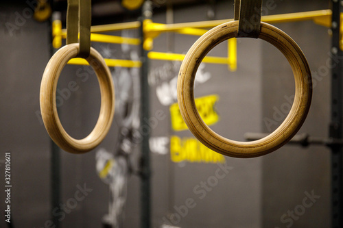 Gymnastic rings hanging at cross fitness gym. Closeup image of a crossfit dip rings in gym interior.