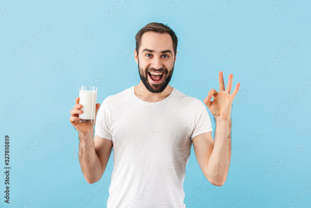 Positive pleased man holding milk. Positive pleased man holding milk.