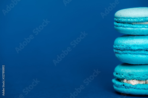 sweet french macaroons on blue background with copy space