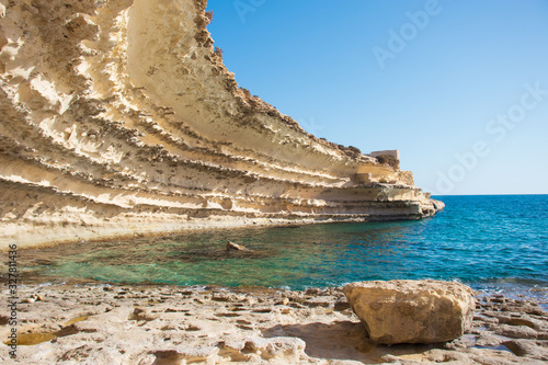 Rocky wall with the cave entrance in the mediterranean sea. Malta. il hofra i kbira photo