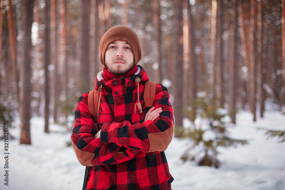 Male tourist with backpack walks on snow pine forest. Guy hiking at nature. Concept of winter holiday or vacation.. Male tourist with backpack walks on snow pine forest. Guy hiking at nature. Concept of winter holiday or vacation..