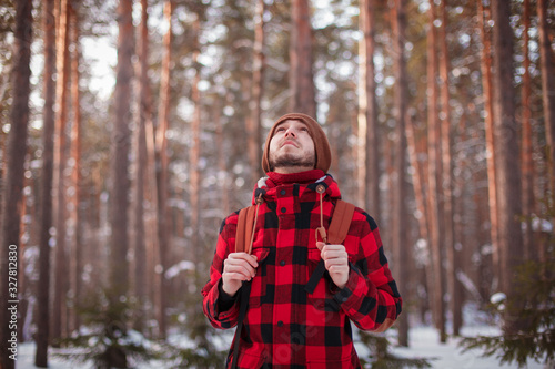 Male tourist with backpack walks on snow pine forest. Guy hiking at nature. Concept of winter holiday or vacation.. © mkphoto2000