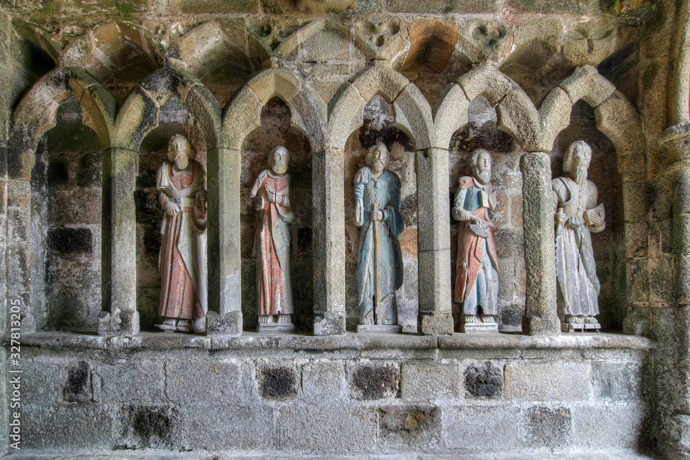 Medieval wooden statues of saints - apostles - at the entrance to the chapel of Kermaria an Iskuit from 13th century