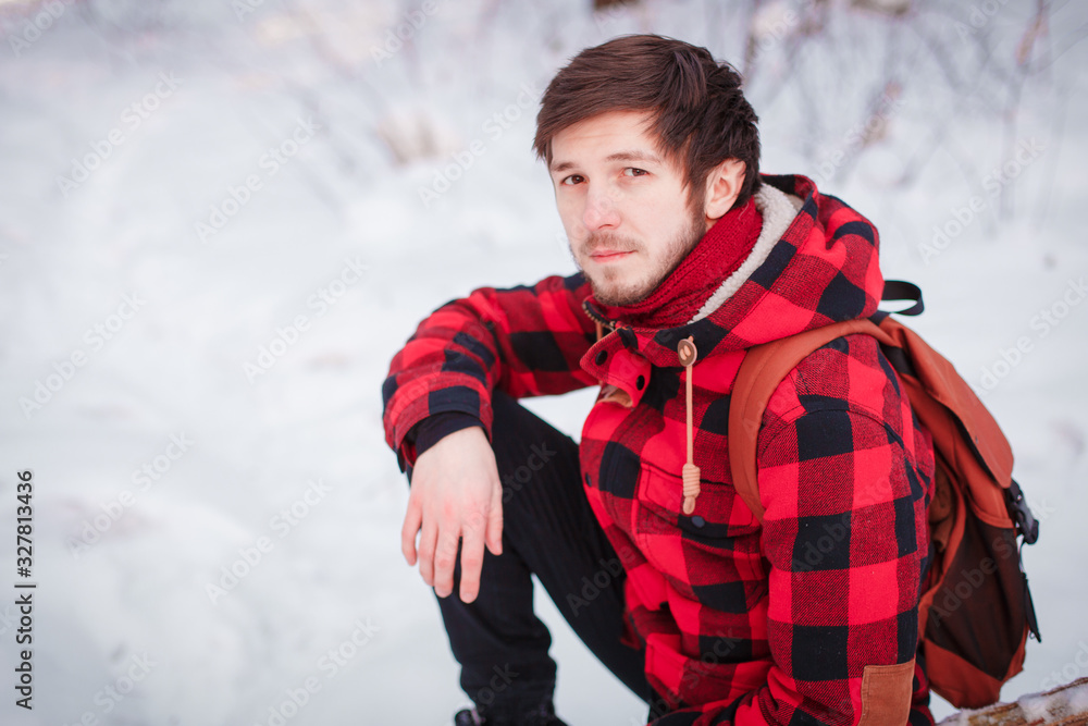 Photo of cheerful male resting, looks directly into camera, sits in snow pine winter forest, smiles happily, enjoys communication, admires landscapes Photo of cheerful male resting, looks directly into camera, sits in snow pine winter forest, smiles happily, enjoys communication, admires landscapes