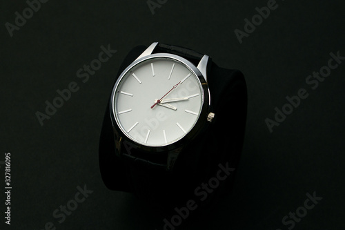 Wristwatch in a red box on a dark background.Watch in a case on a black velvet pillow