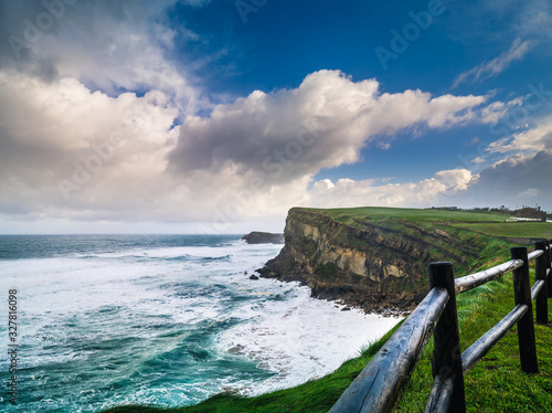 Cliffs of La Tablía in storm day with strong waves and cloudy s photo