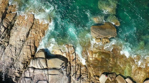 SLOW MOTION : Aerial top view of ocean waves, Beautiful tropical beach and rocky coastline. Nga Khin Nyo Gyee Island Myanmar photo