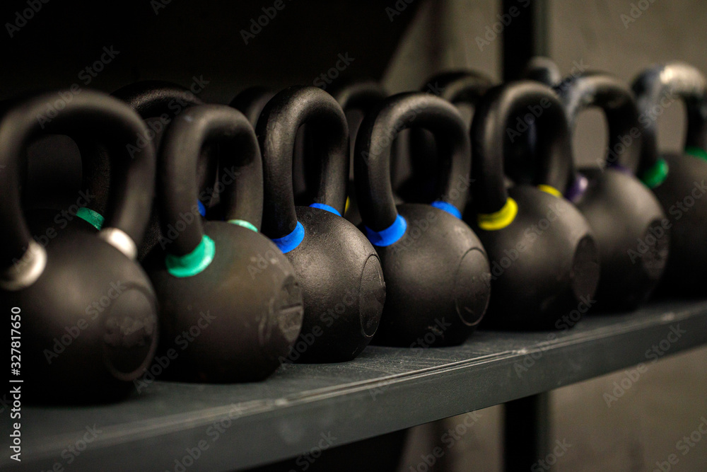 Colorful kettlebells in a row in a gym. Heavy iron kettlebells on the