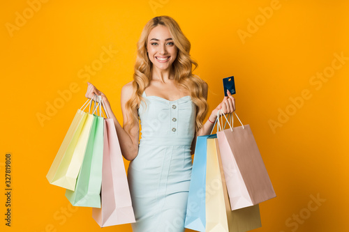 Spring sale. Woman showing credit card and shopping bags