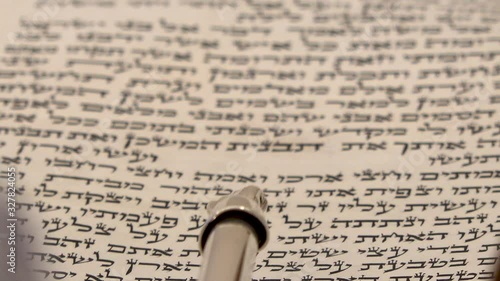 Torah bible reading text with pointer. Aramaic and Hebrew letters from holy book Zohar or Kabbalah. Close up shot on sacred spiritual texts