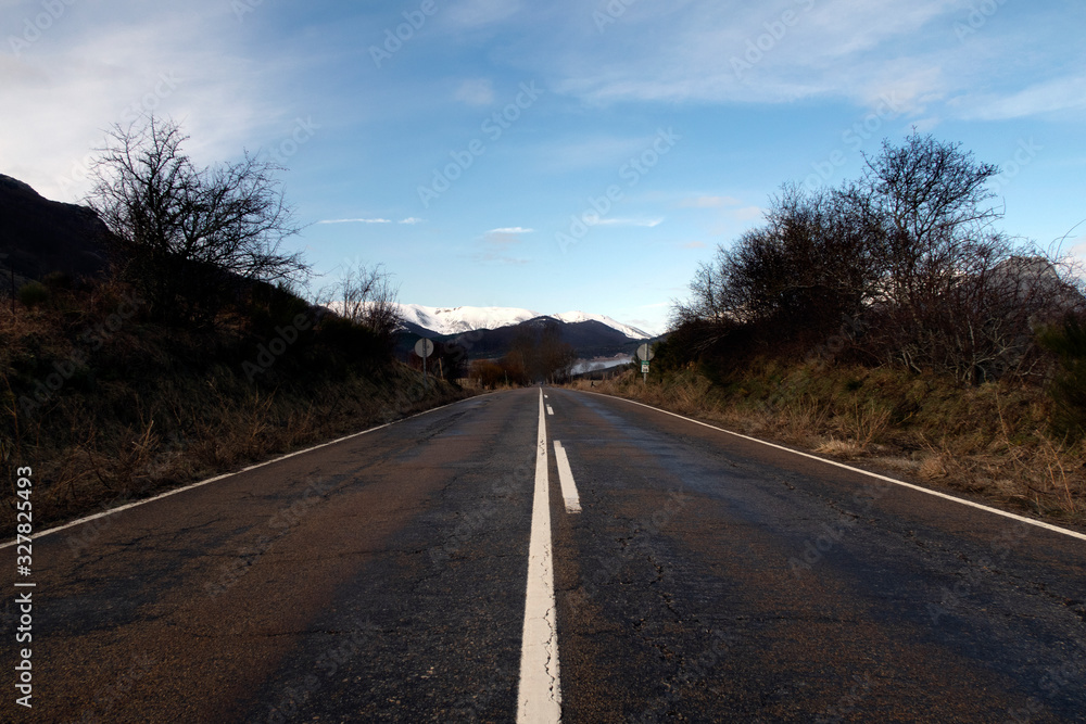 Empty road to snowy mountain. Desert. Asturias, Peaks of Europe, Spain.
