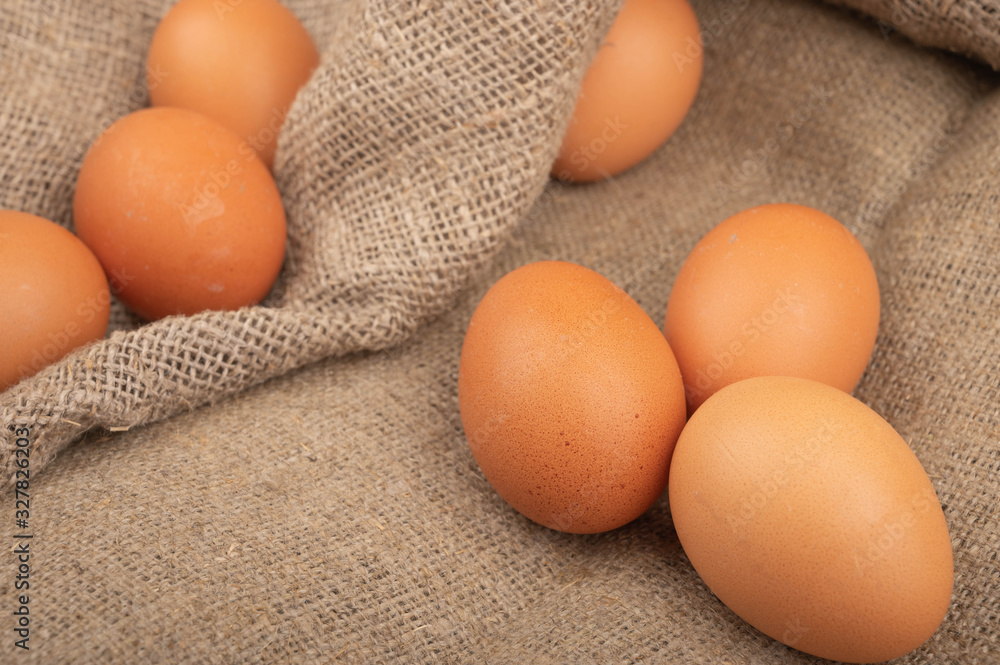 Chicken eggs on a background of rough homespun fabric. Homemade preparations, rustic treats. Close up. Chicken eggs on a background of rough homespun fabric. Homemade preparations, rustic treats. Close up.
