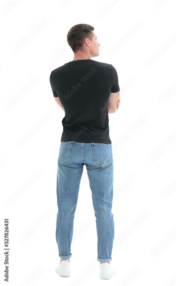 Fototapeta premium rear view. guy in a black t-shirt staring at a white wall