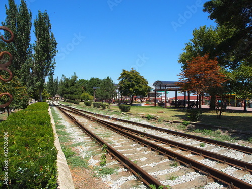 Railway tracks laid along the waterfront of the seaside town , summer day.