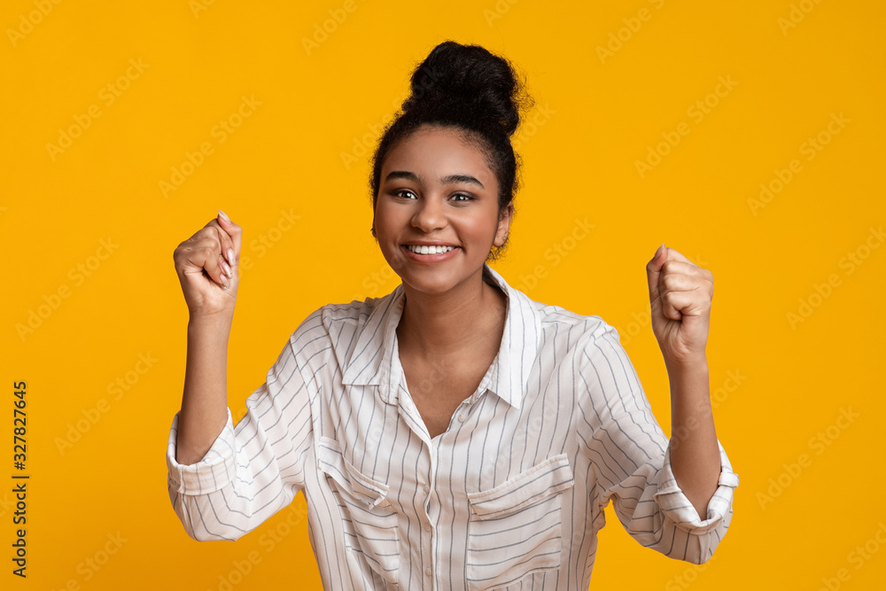 Joyful Girl Raising Hands In Excitement, Celebrating Success With Clenched Fists Joyful Girl Raising Hands In Excitement, Celebrating Success With Clenched Fists