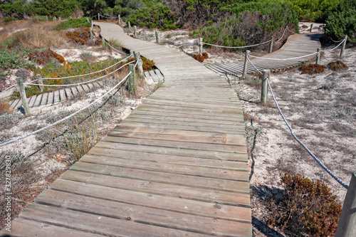 A wooden walkway allows you to walk the beautiful dunes on the coast of Formentera in the Balearic islands of Spain.