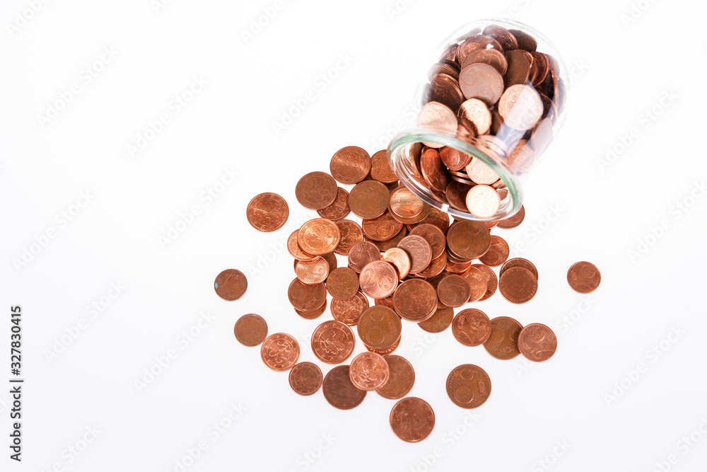 Small change euro cent coins pouring out of glass jar. End of small coins in the European Union Small change euro cent coins pouring out of glass jar. End of small coins in the European Union