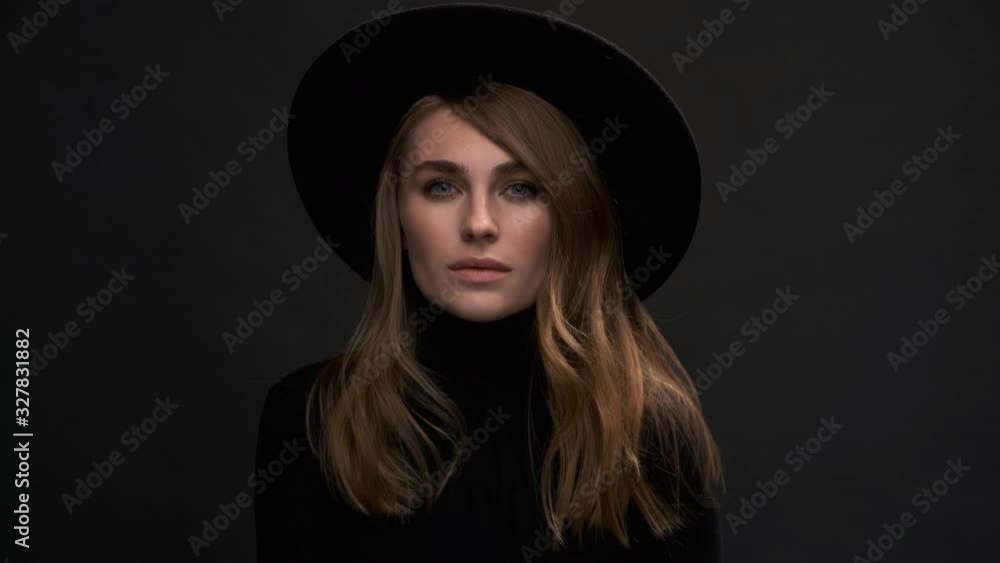 Portrait of a beautiful young blonde woman in a black hat with fields and a sweater. Romantic retro fashion image. A sensual emotional woman. Portrait of a beautiful young blonde woman in a black hat with fields and a sweater. Romantic retro fashion image. A sensual emotional woman.