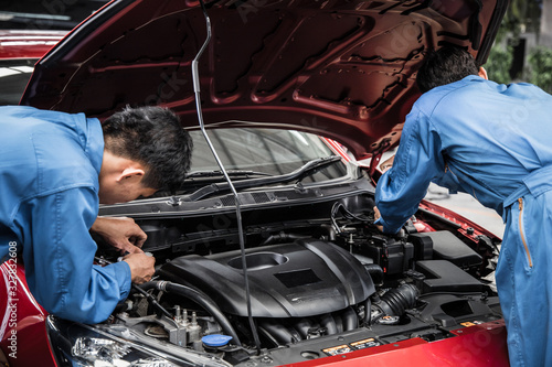 Two auto mechanic doing car service and maintenance. © P Stock