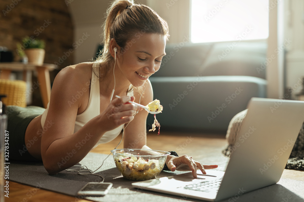 Smiling athletic woman using laptop while healthy food at home. Smiling athletic woman using laptop while healthy food at home.