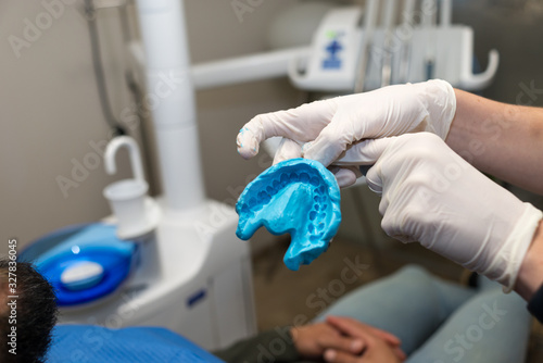 Dentist hands with latex gloves holding dental mold of the patient. photo