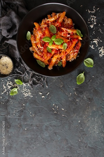 Fotomural Penne pasta with tomato sauce, parmesan cheese and basil on dark background