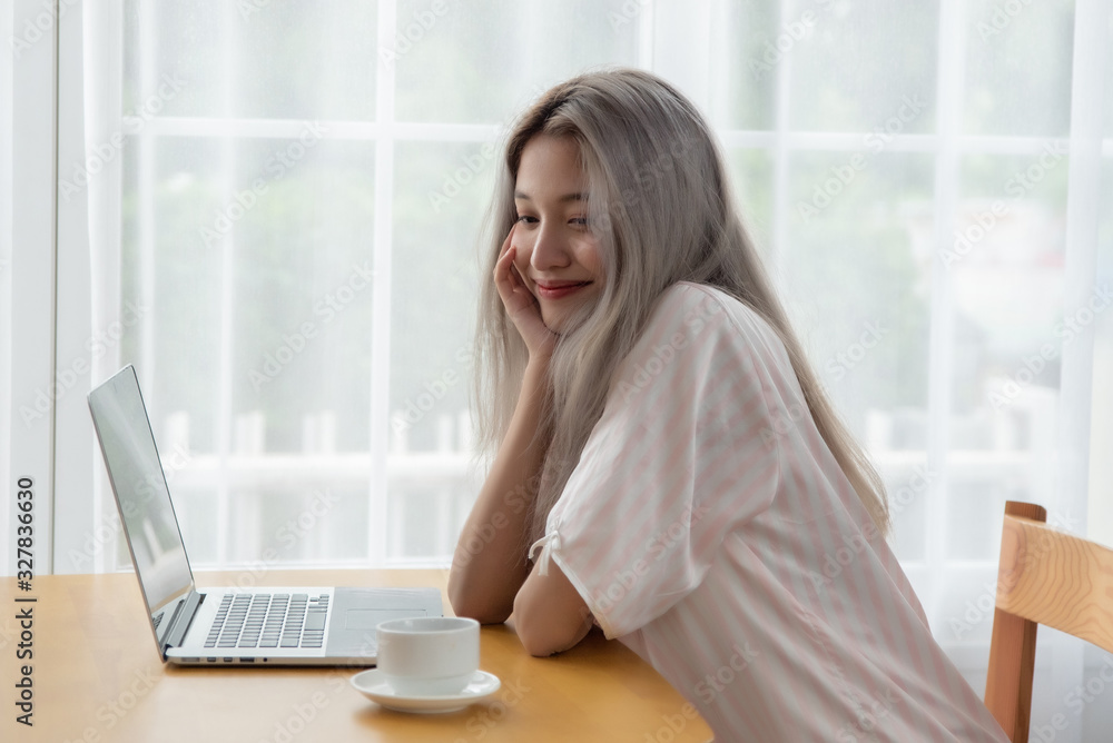 Lazy bored asian woman using laptop in the morning. Lazy bored asian woman using laptop in the morning.