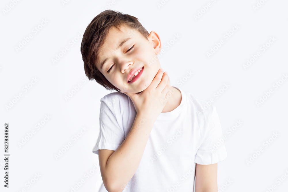Closeup portrait of sad child with sore throat holding his neck with hand isolated on white background. Worldwide epidemic of coronavirus covid-2019. Health and medical care. Quarantine. Insurance. Closeup portrait of sad child with sore throat holding his neck with hand isolated on white background. Worldwide epidemic of coronavirus covid-2019. Health and medical care. Quarantine. Insurance.