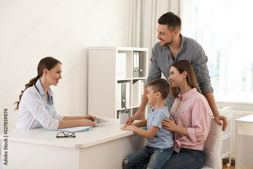 Parents and son visiting pediatrician. Doctor working with patient in hospital Parents and son visiting pediatrician. Doctor working with patient in hospital