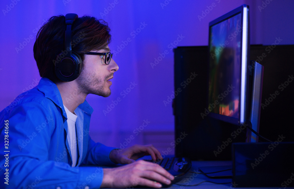 Gamer Taking Part In Online Tournamet Sitting At Computer Indoor Gamer Taking Part In Online Tournamet Sitting At Computer Indoor