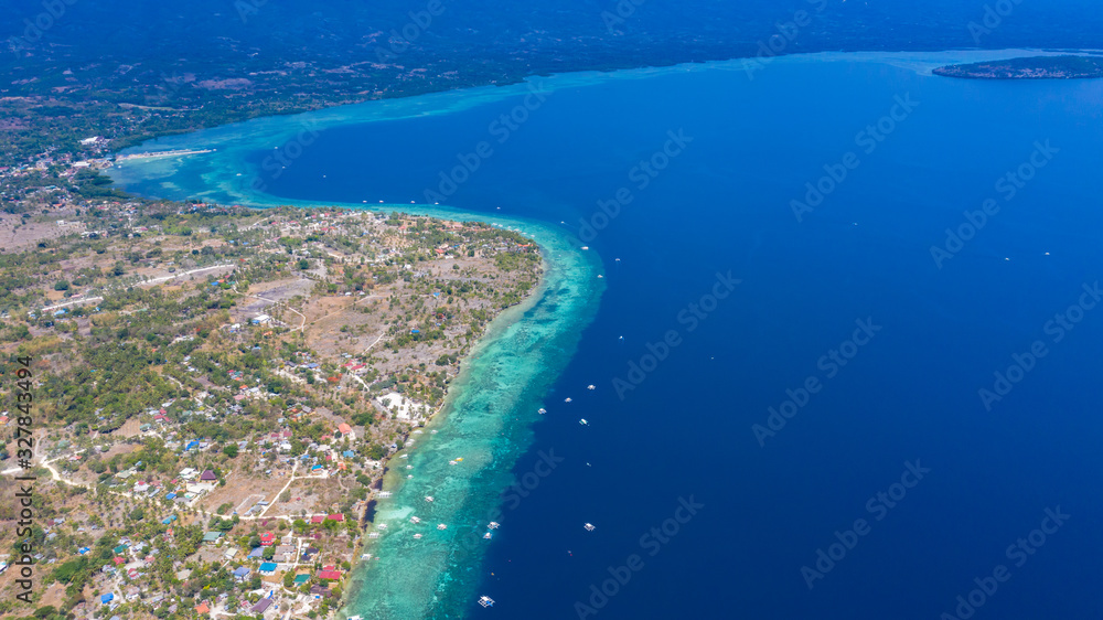 Aerial view local living of Philippines at Moalboal a small town on Cebu island, Moalboal is a deep clean blue ocean and has many local Filipino boats in the sea. Moalboal, Cebu, Philippines.