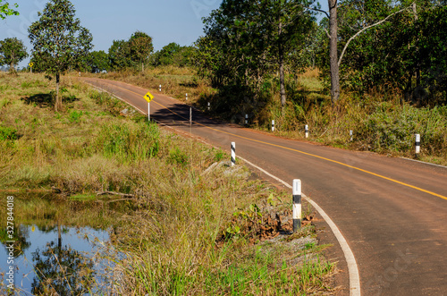 The road in the top bumped with green pastures and puddles on the side of the road.