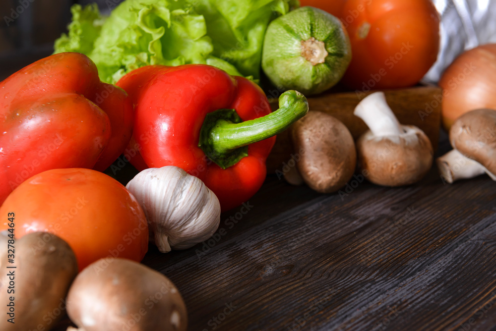 vegetables, zucchini, tomato, red bell pepper, garlic, mushrooms, green salad leaves on a wooden vegetables, zucchini, tomato, red bell pepper, garlic, mushrooms, green salad leaves on a wooden