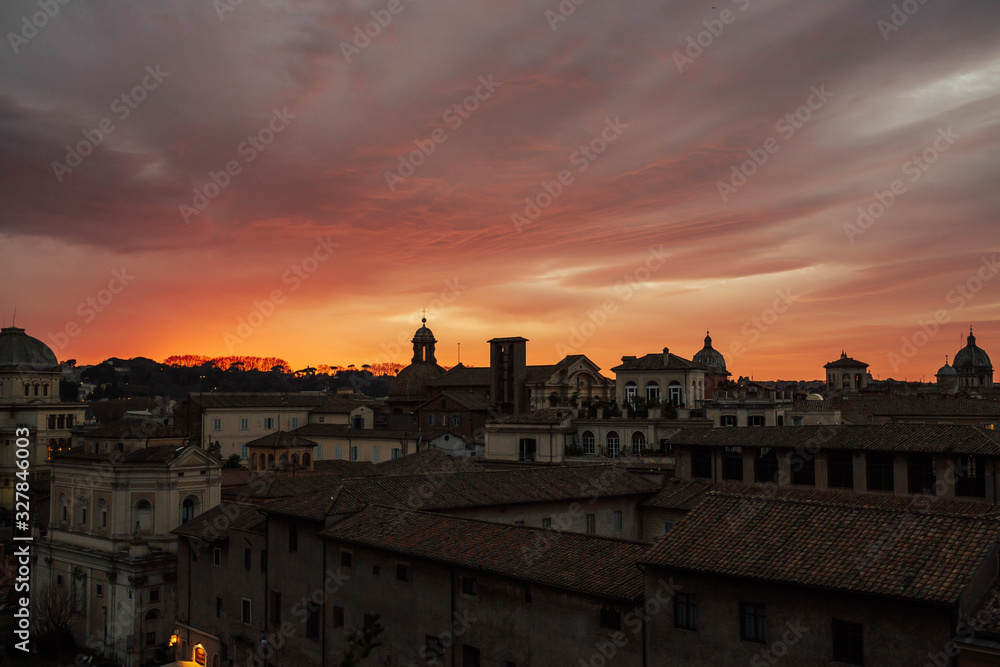 Panorama with ancient architecture in Italy at sunset with rose and orange clouds. Rome rooftop view at sunset panorama with ancient architecture in Italy.