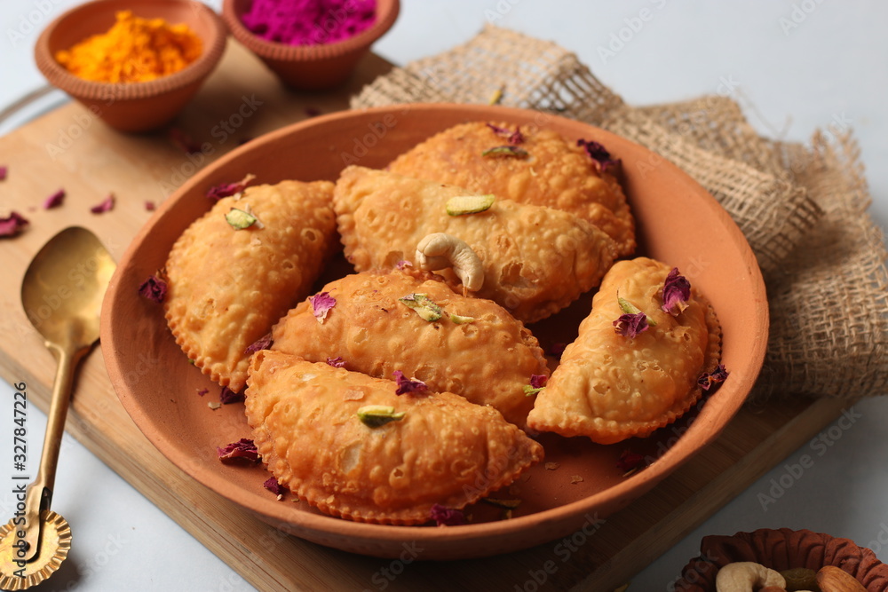 Popular Holi Snack known as Karanji or Gujia is Served on earthen platter. (Holi Concept) Popular Holi Snack known as Karanji or Gujia is Served on earthen platter. (Holi Concept)