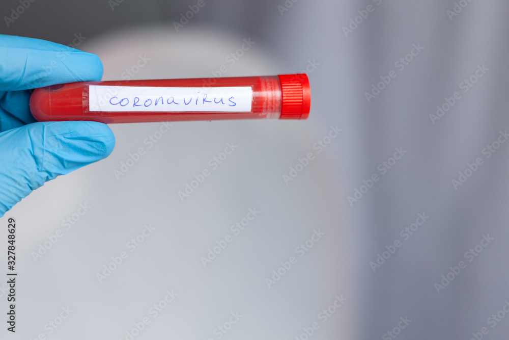 Obraz premium test tube in hand, inscription virus, coronavirus study, virus research