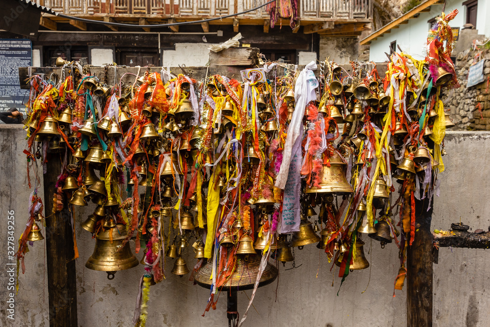 Bronze temple bells with prayers written on colorful ribbons inside the ancient Hindu temple at Muktinath in Mustang, Nepal.