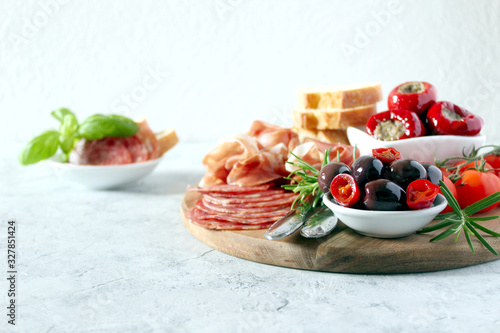 Antipasto: ham, olives, salami, tomato, pepper and bread. Top view with copy space.