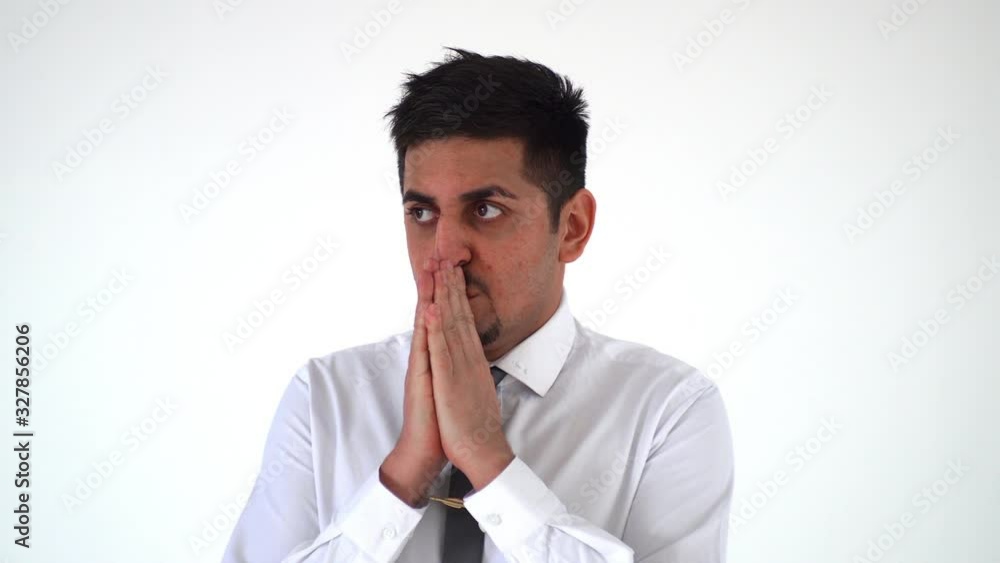 the man holds his folded hands to his face. A businessman experiencing a problem the man holds his folded hands to his face. A businessman experiencing a problem