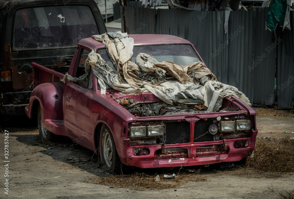 Old pink pickup truck abandoned in wasteland, car covered with old rags, car scrap 