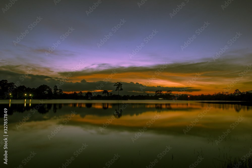 Wallpaper blurred nature of the twilight light in the evening by the large water basin surrounded by big trees, the integrity of the forest Wallpaper blurred nature of the twilight light in the evening by the large water basin surrounded by big trees, the integrity of the forest